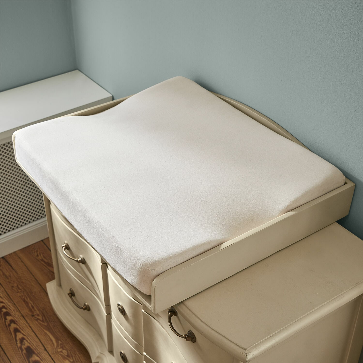 Matelas à langer Aiguillon Coussin beige doux en tissu pour table à langer sur commode crème dans une chambre d'enfant
