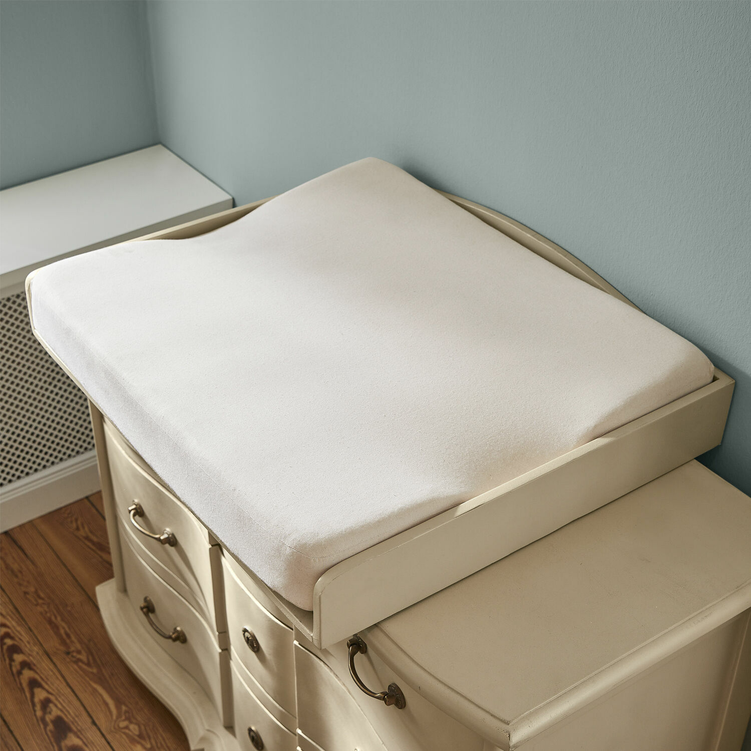 Matelas à langer Aiguillon Coussin beige doux en tissu pour table à langer sur commode crème dans une chambre d'enfant