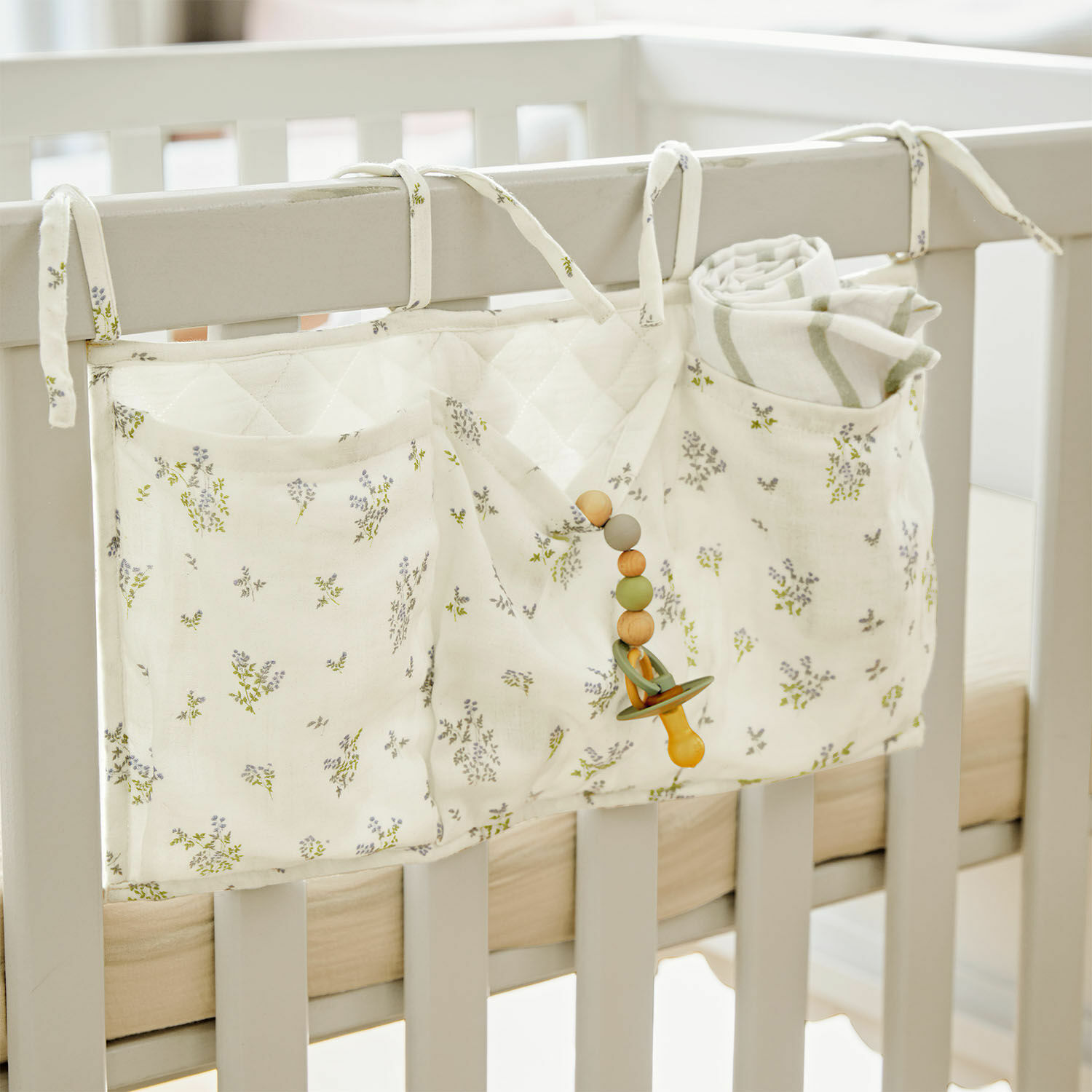 Organisateur de lit Nymariel Organisateur de lit bébé en coton crème à motif floral avec poches pour accessoires bébé