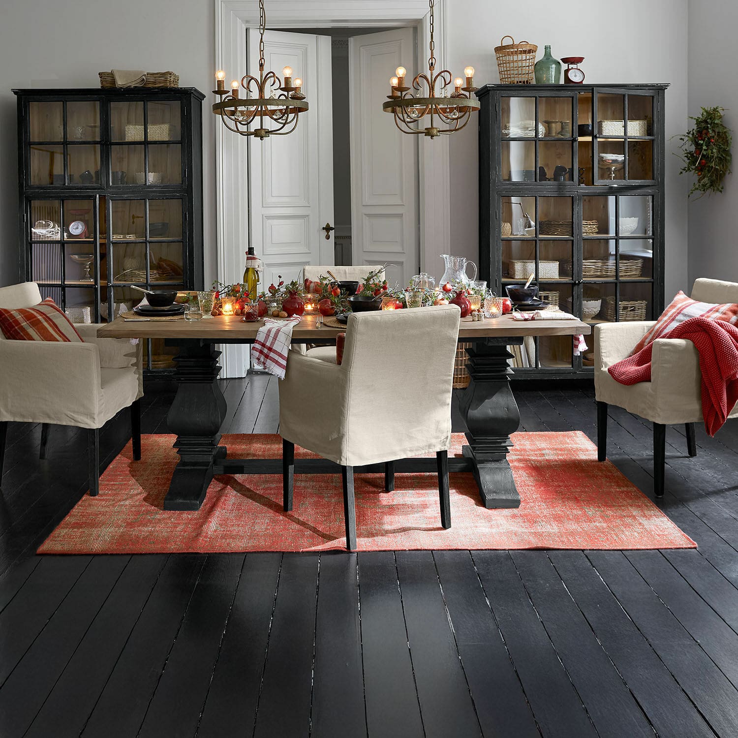 Tapis Yalora Salle à manger avec table en bois et chaises beige sur tapis rouge, ambiance rustique chaleureuse