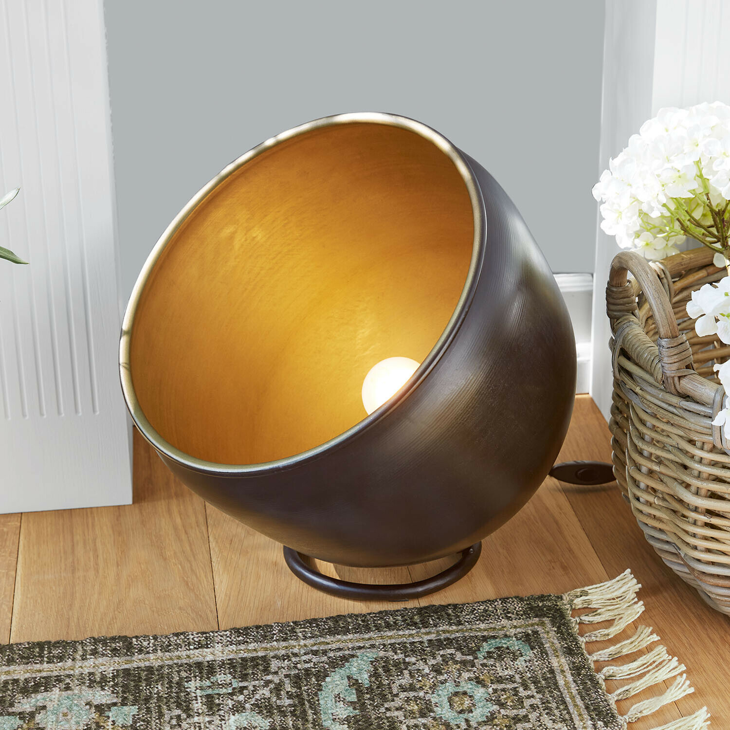 Lampe de sol Moorford Lampe de table en métal avec intérieur doré et extérieur noir posée sur un sol en bois