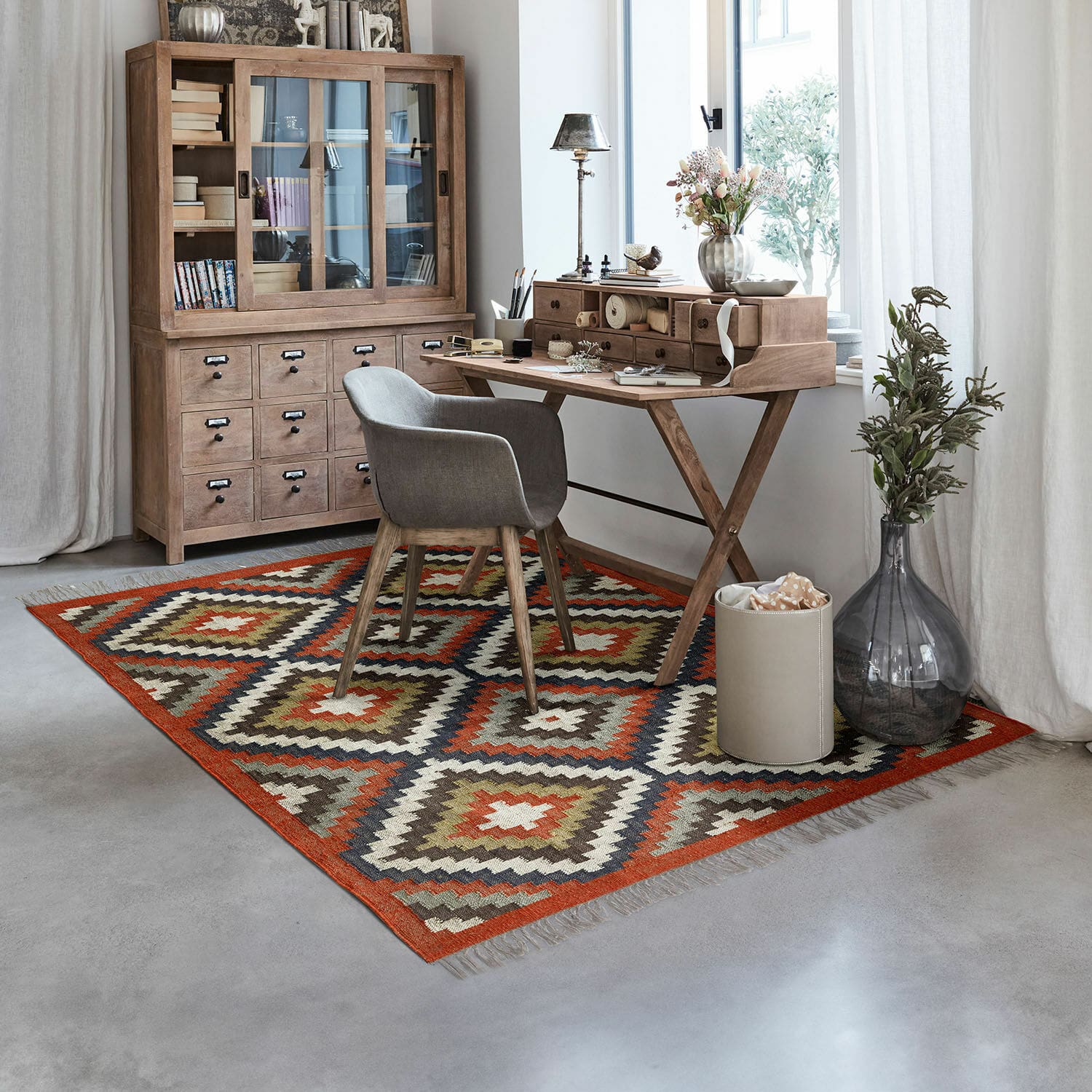 Tapis Dailies Tapis à motif géométrique aux tons chauds dans un bureau moderne avec bureau et armoire en bois