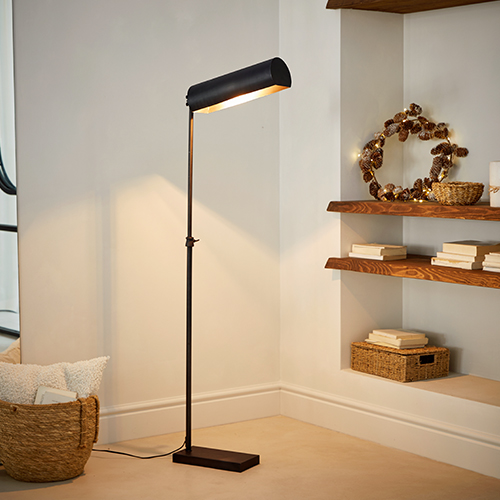 Lampadaire noir en métal avec abat-jour réglable dans un intérieur moderne avec étagères en bois