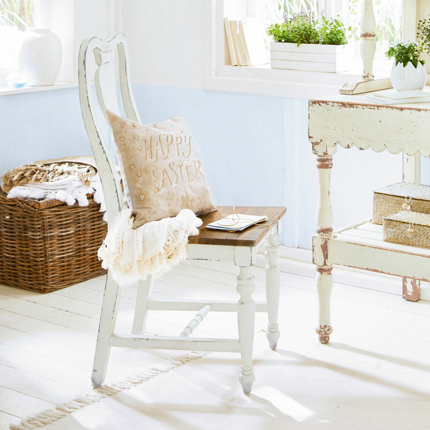 Chaise Harry Chaise en bois blanc avec assise marron et coussin beige Happy Easter dans un intérieur lumineux