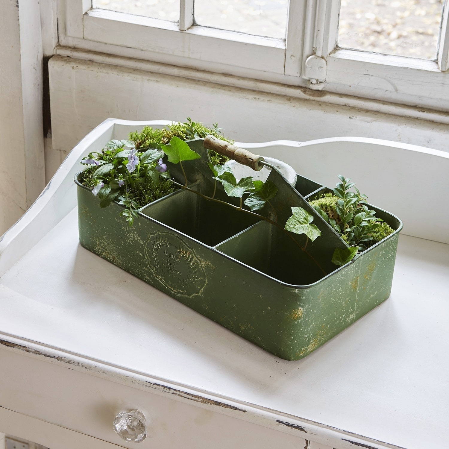 Caissette Brea Boîte en métal verte avec compartiments et poignée en bois, décorée de plantes et de mousse