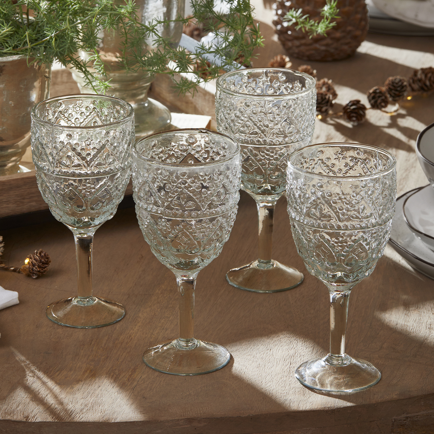 Ensemble de quatre verres transparents avec motif décoratif sur table en bois pour servir des boissons