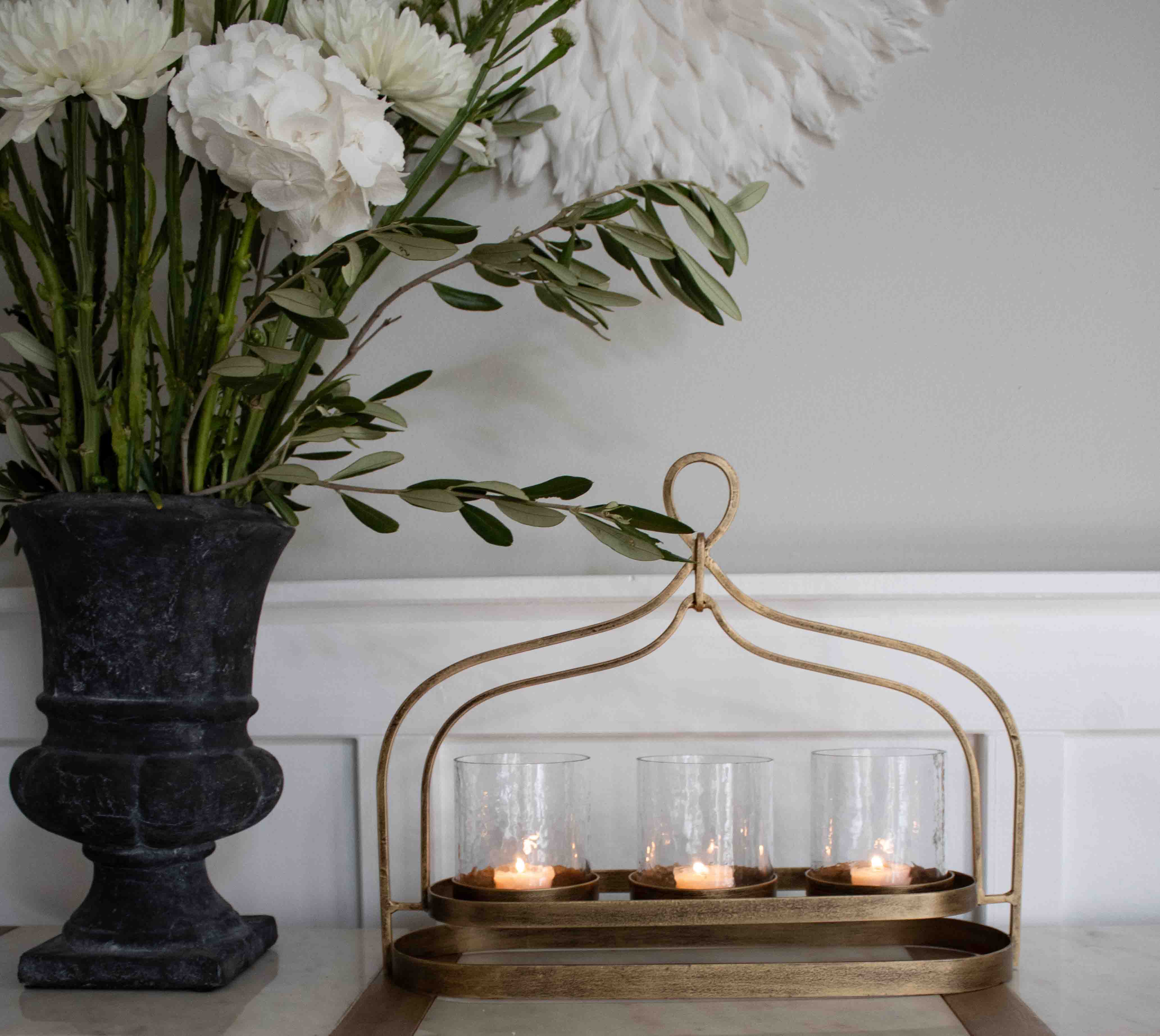 Bougeoir en métal doré avec trois verres pour bougies chauffe-plat sur une table décorative