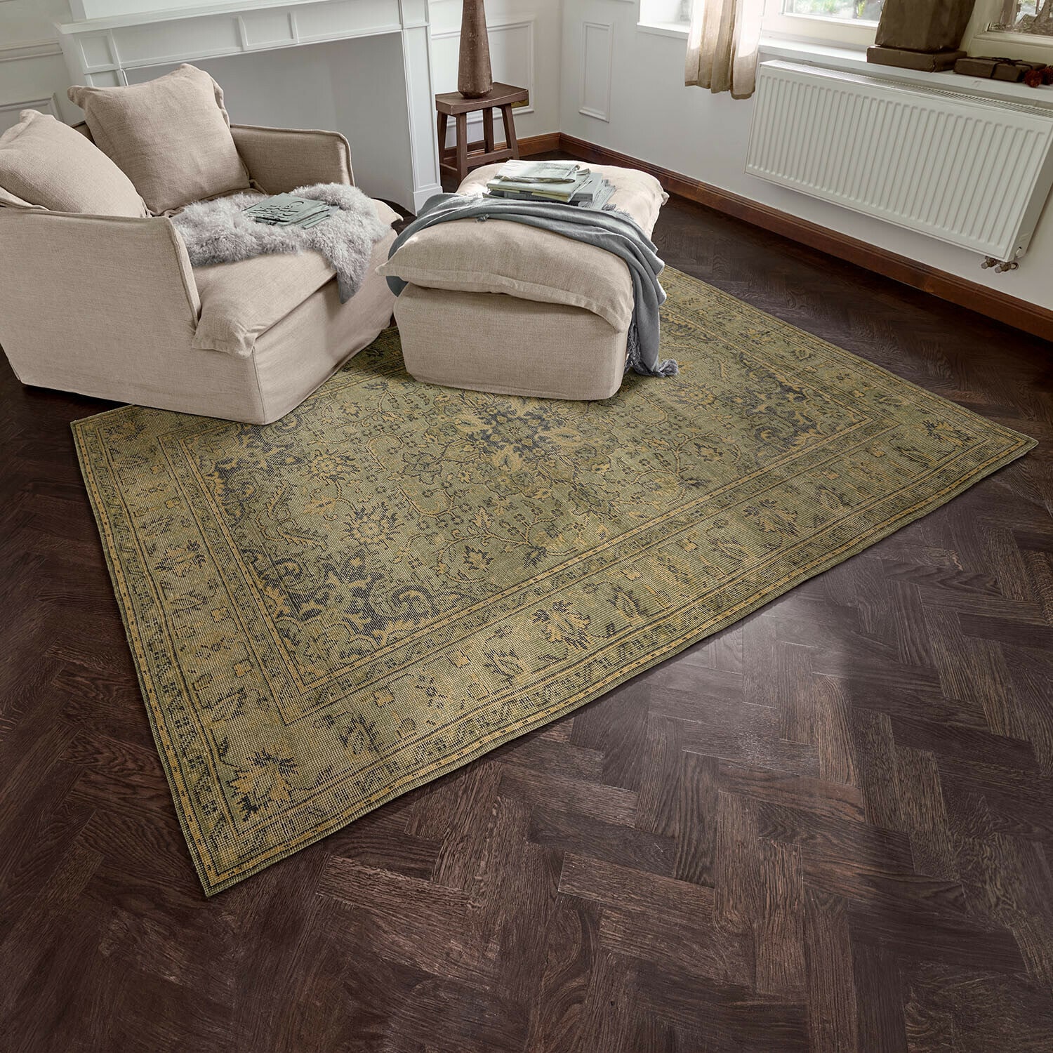 Tapis Marouan Tapis beige à motif oriental sur parquet foncé dans un salon avec fauteuil beige et pouf