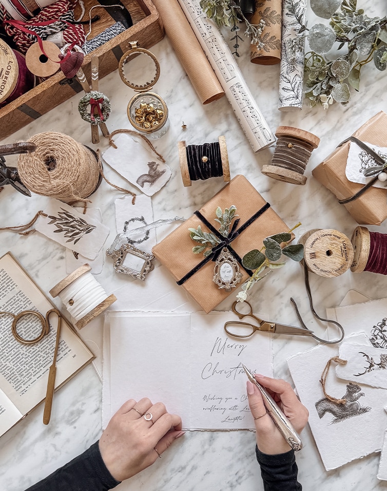 Carte de vœux de Noël artisanale avec décorations naturelles et matériel d'emballage sur table en marbre