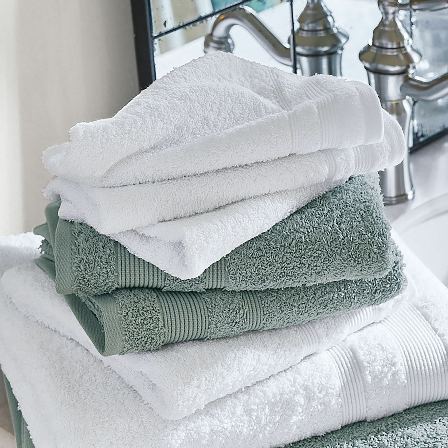Lot de 4 serviettes Bourogne Serviettes en coton douces blanches et vertes empilées dans une salle de bain moderne