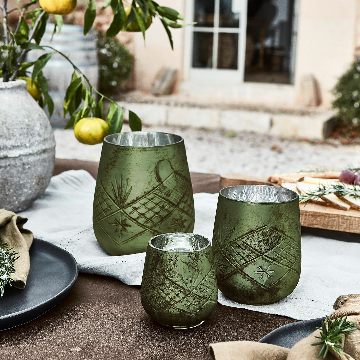 Lot de 3 photophores Vitas Ensemble de trois photophores verts en verre avec motif, décoration de table rustique