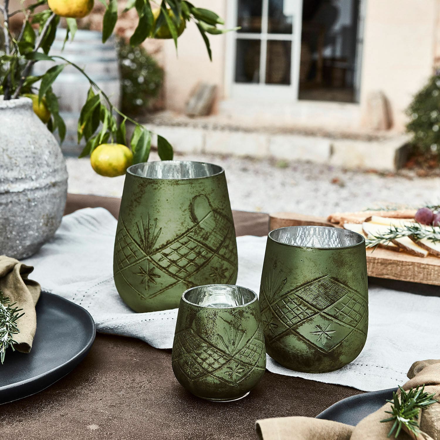 Lot de 3 photophores Vitas Ensemble de trois photophores verts en verre avec motif, décoration de table rustique