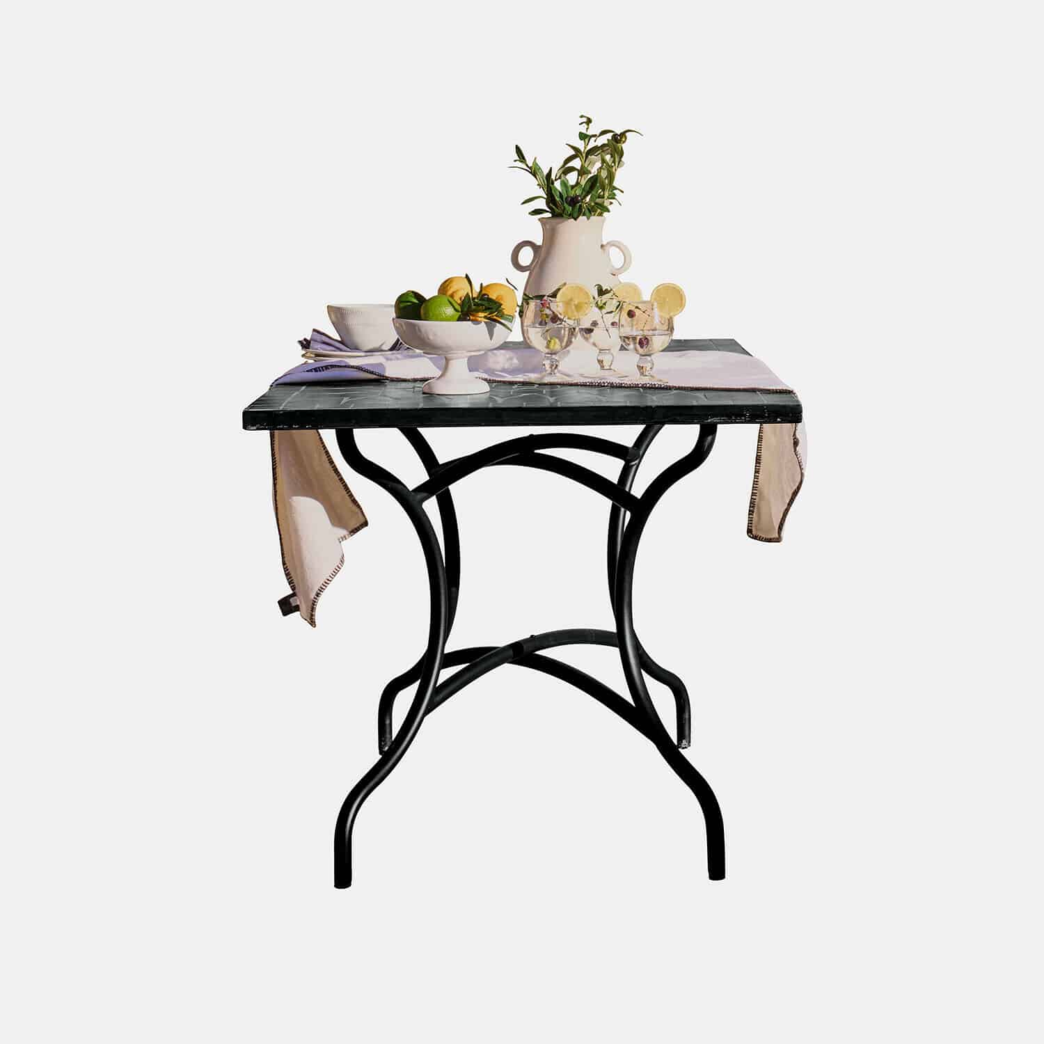 Table Maurelle Table avec pied en métal noir et plateau en marbre décorée de fruits et d’un vase