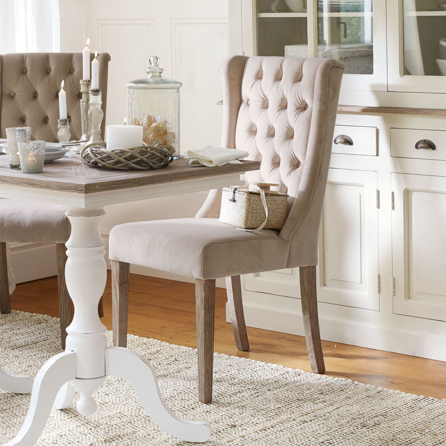 Chaise Sudbury Chaise beige rembourrée avec pieds en bois dans une salle à manger élégante avec tapis et table blanche