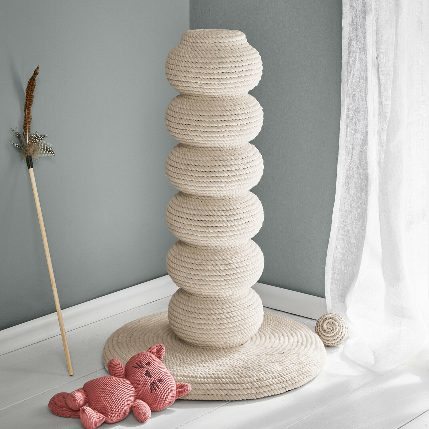 Griffoir pour chat en corde naturelle crème avec jouet et peluche chat rose au sol