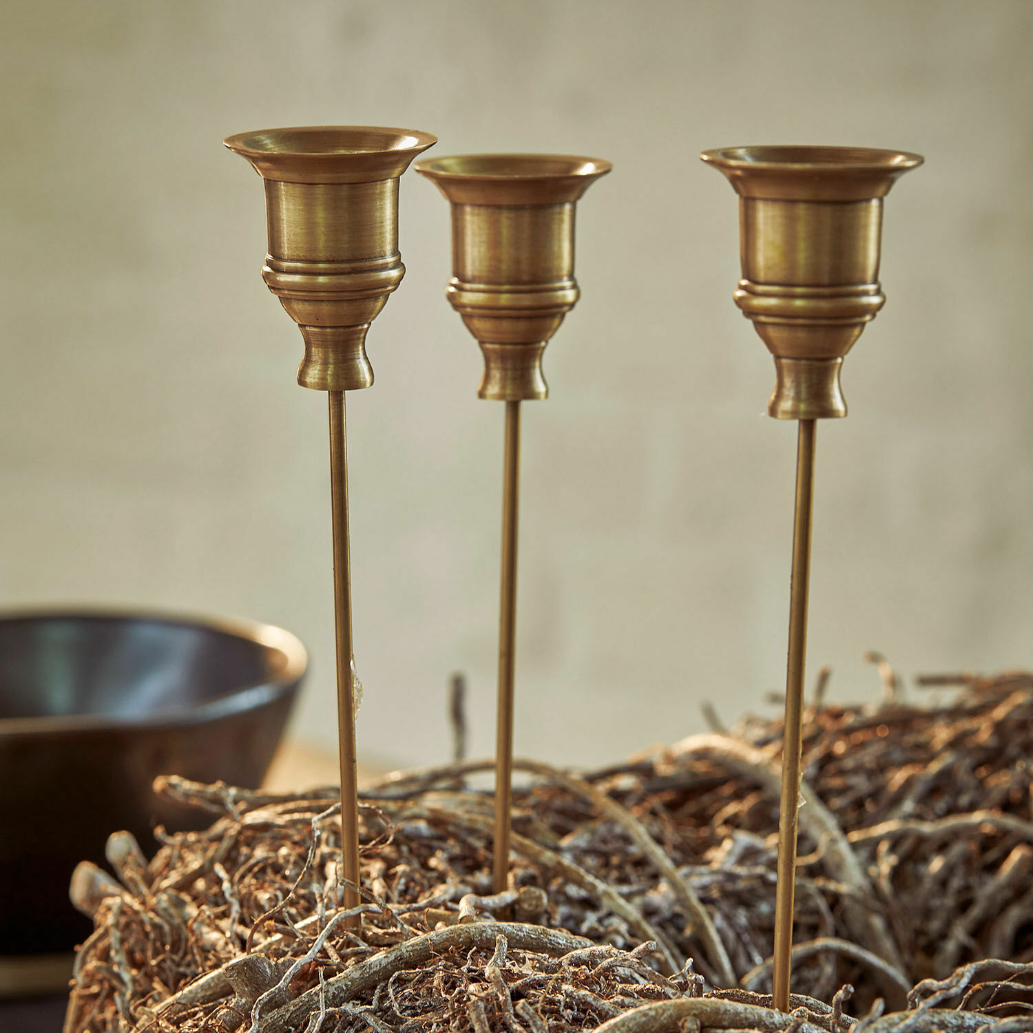 Lot de 3 bougeoirs à piquer Lalley Trois bougeoirs en laiton sur tiges longues dans une décoration naturelle en branches, déco intérieure