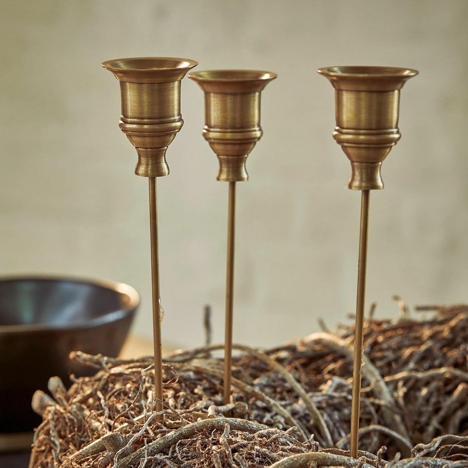 Lot de 3 bougeoirs à piquer Lalley Trois bougeoirs en laiton sur tiges longues dans une décoration naturelle en branches, déco intérieure