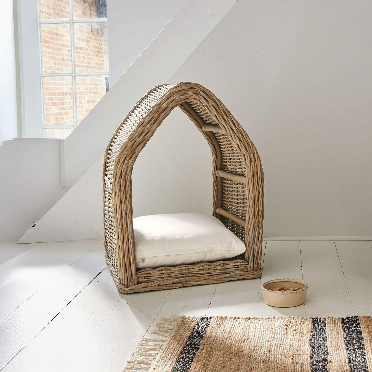 Niche Muffan Maison pour chat en rotin naturel avec coussin blanc et bol pour friandises à côté