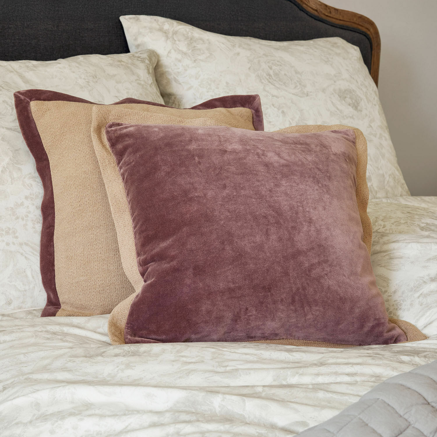 Lot de 2 housses de coussins Liréan Ensemble de coussins décoratifs en velours et lin rose et beige sur un lit avec linge de lit à motif floral
