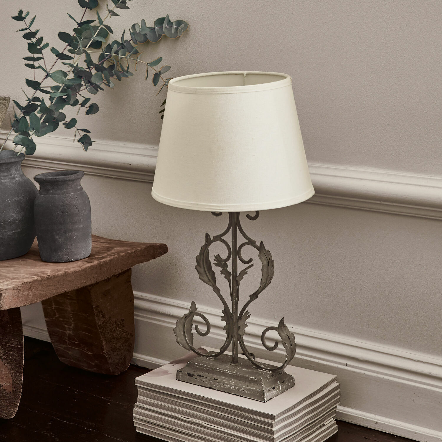 Lampe à poser Chanéac Lampe de table avec base en métal gris et abat-jour crème posée sur un sol en bois