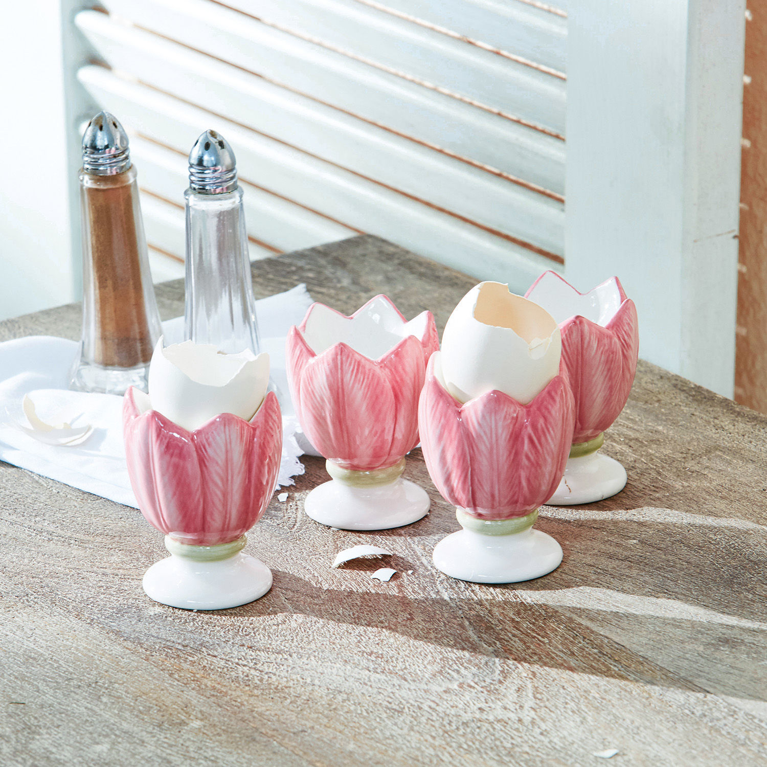Lot de 4 coquetiers Mireille Porte-œufs en céramique rose en forme de tulipe sur table en bois avec salière et poivrière