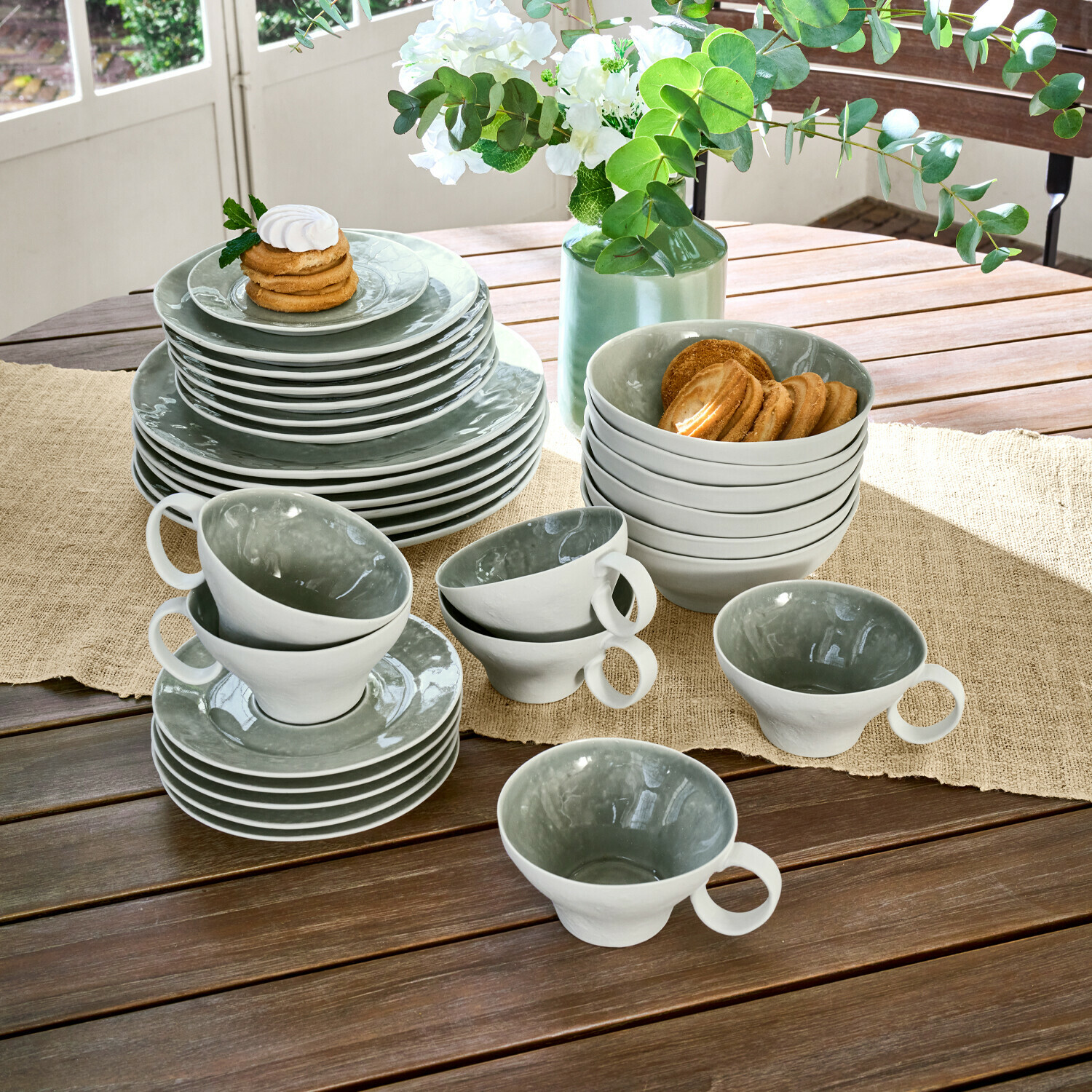 Service 30 pièces Braganza Service de vaisselle en céramique gris et blanc sur table en bois avec biscuits, décoration florale