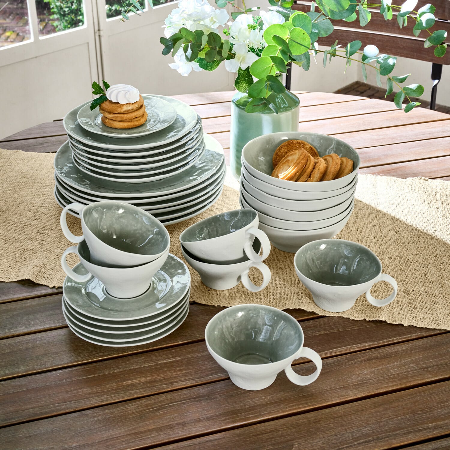 Service 30 pièces Braganza Service de vaisselle en céramique gris et blanc sur table en bois avec biscuits, décoration florale