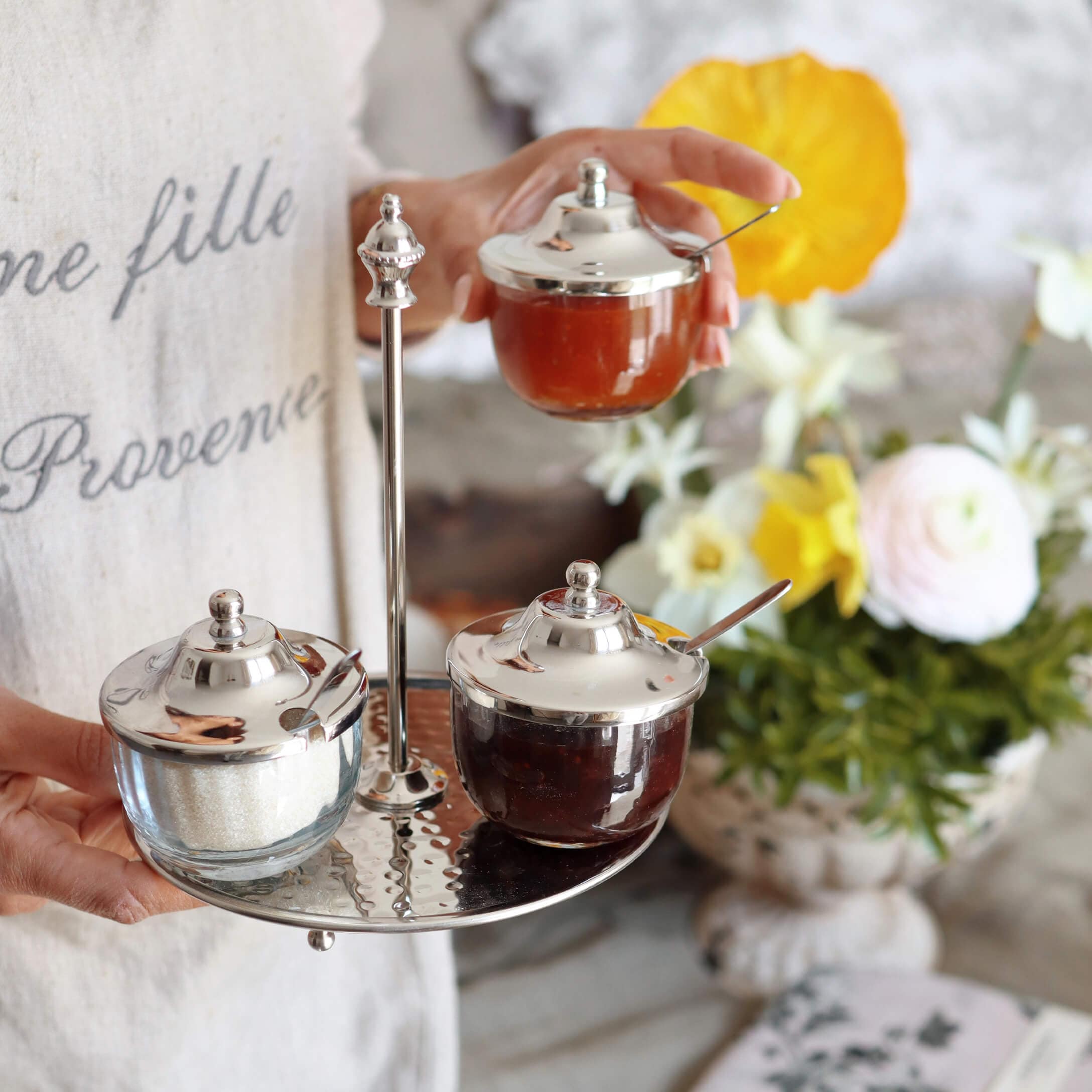 Pots en verre avec couvercles métalliques sur plateau en métal, contenant confiture et sucre