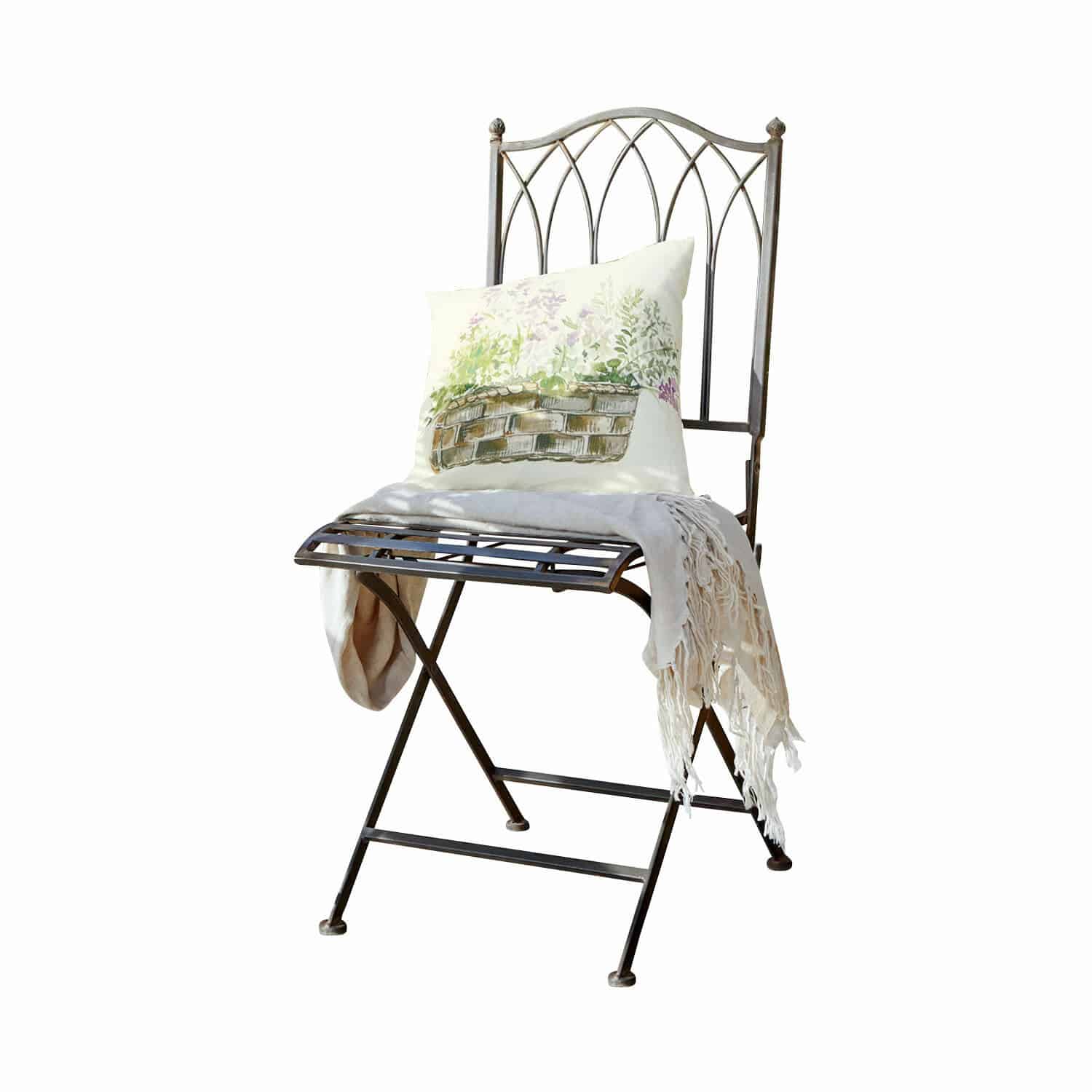 Chaise Brignoles Chaise en métal avec dossier décoratif, coussin clair imprimé et plaid crème à franges posé dessus