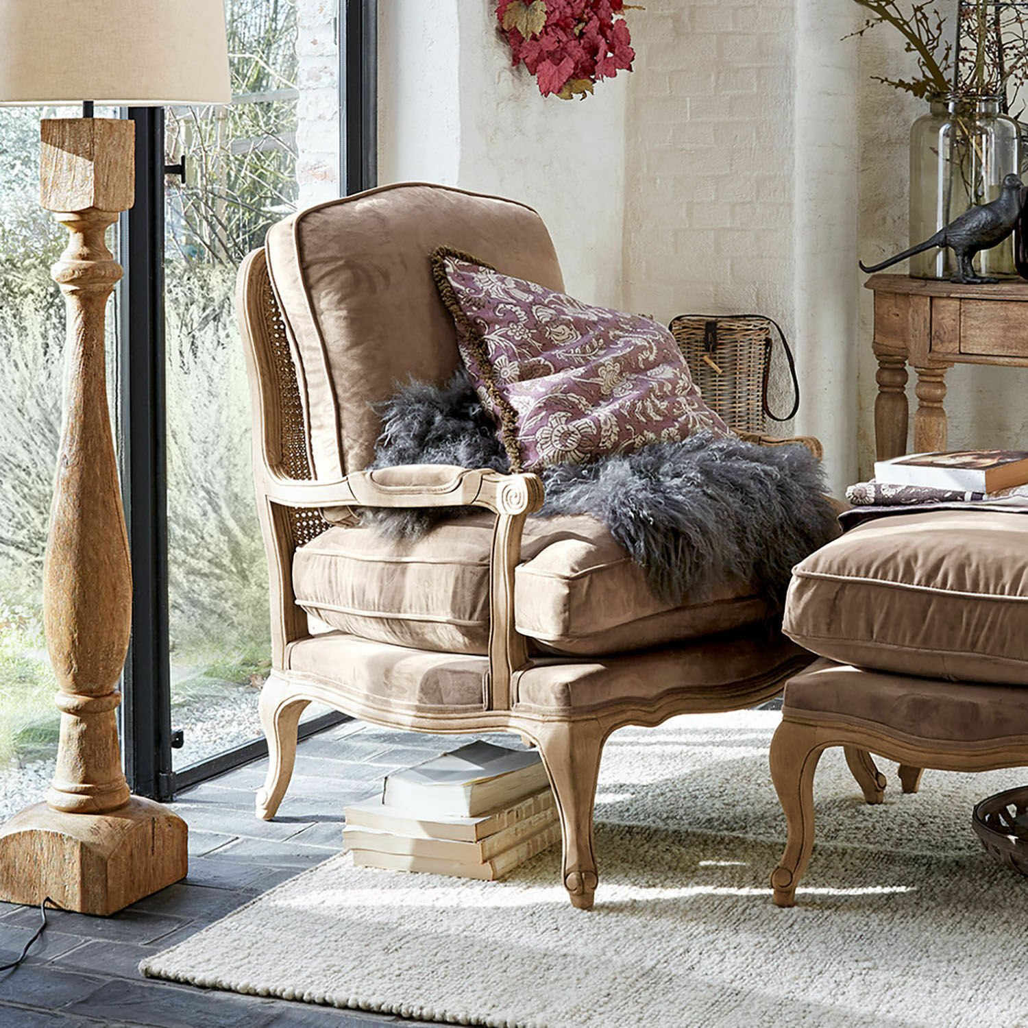 Fauteuil Corlay Fauteuil beige en velours avec cadre en bois et coussin décoratif dans un salon lumineux