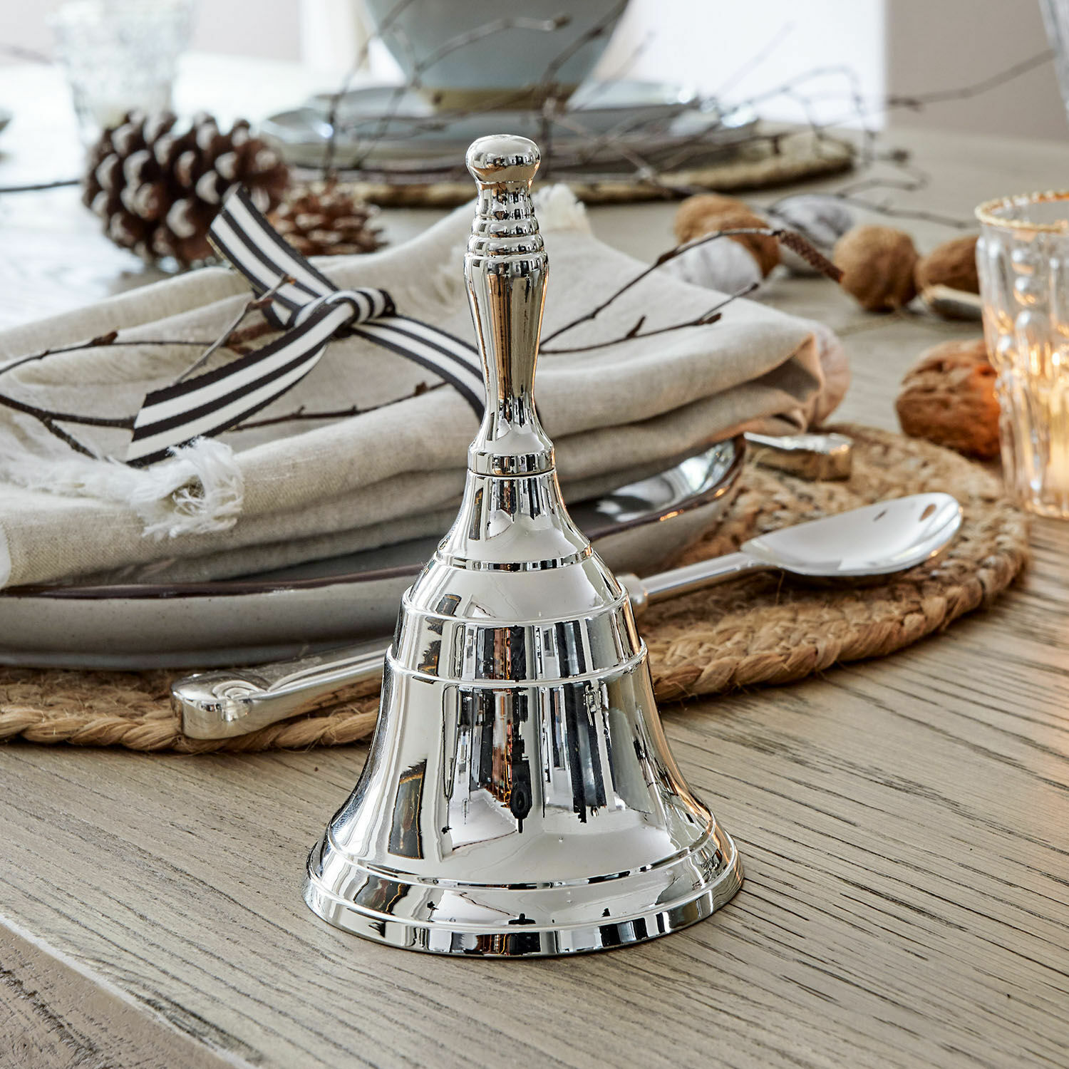 Cloche Baron Cloche de table en métal argenté sur table en bois avec décoration et couverts