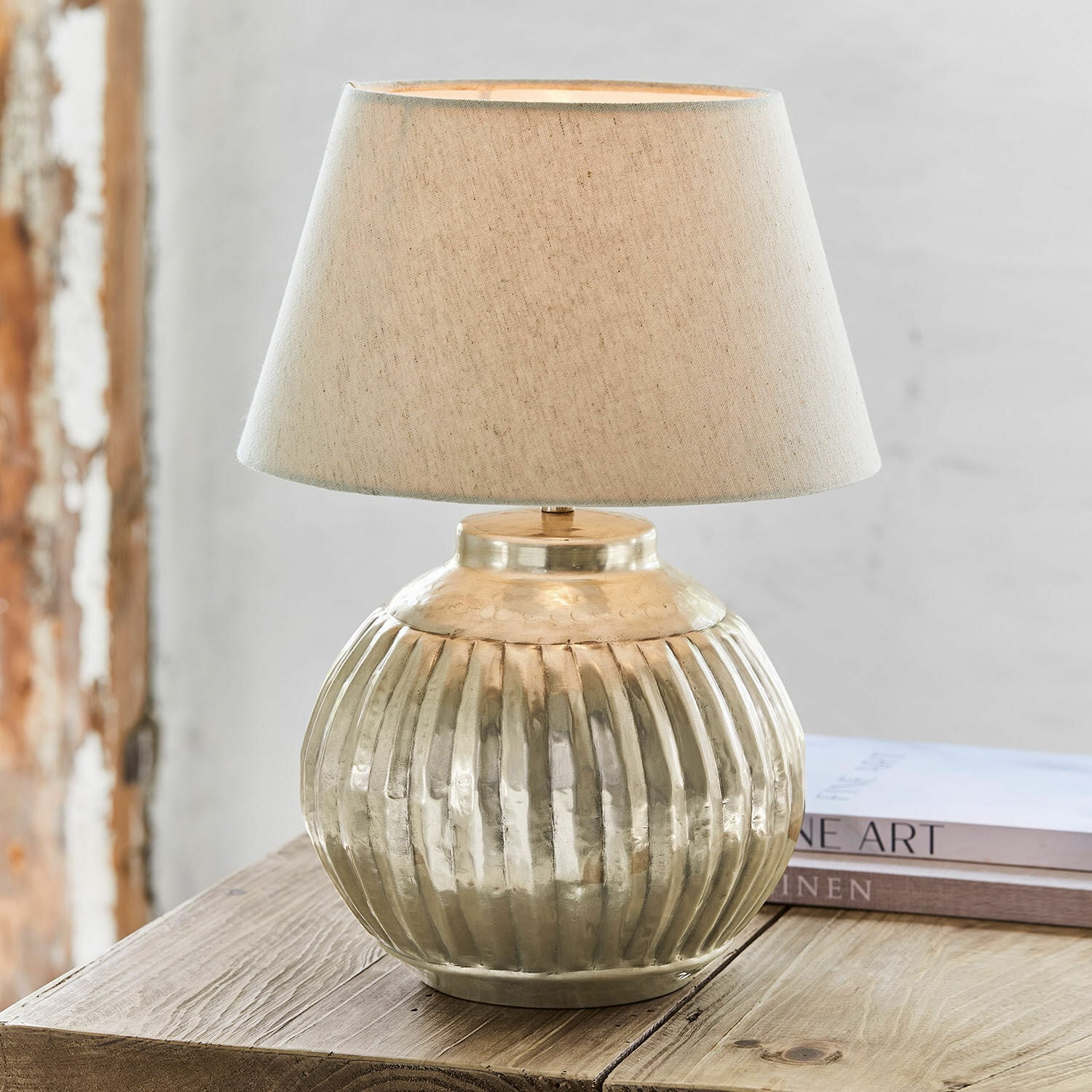 Lampe à poser Lillemor Lampe de table en laiton avec abat-jour beige posée sur une table en bois, décoration intérieure