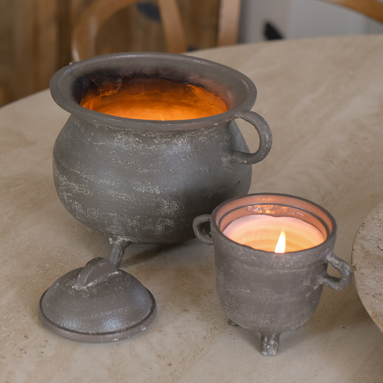 Ensemble de deux bougeoirs en métal gris, un avec couvercle, posés sur une table claire