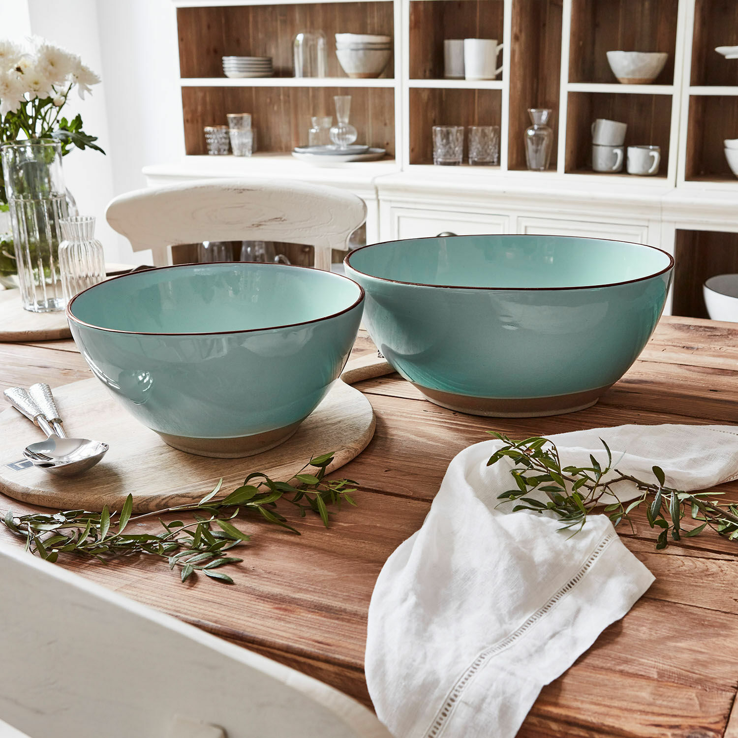 Lot de 2 saladiers Biarré Ensemble de deux bols en céramique turquoise sur une table en bois avec décoration de branches vertes