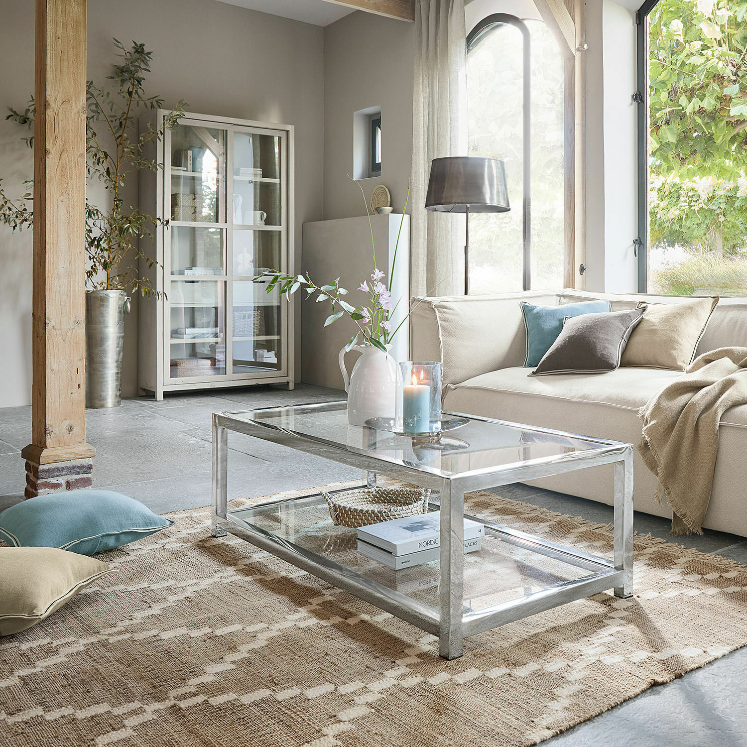 Tapis d’intérieur et d’extérieur Piera Table basse moderne en verre avec cadre métallique dans un salon clair avec canapé beige et décorations