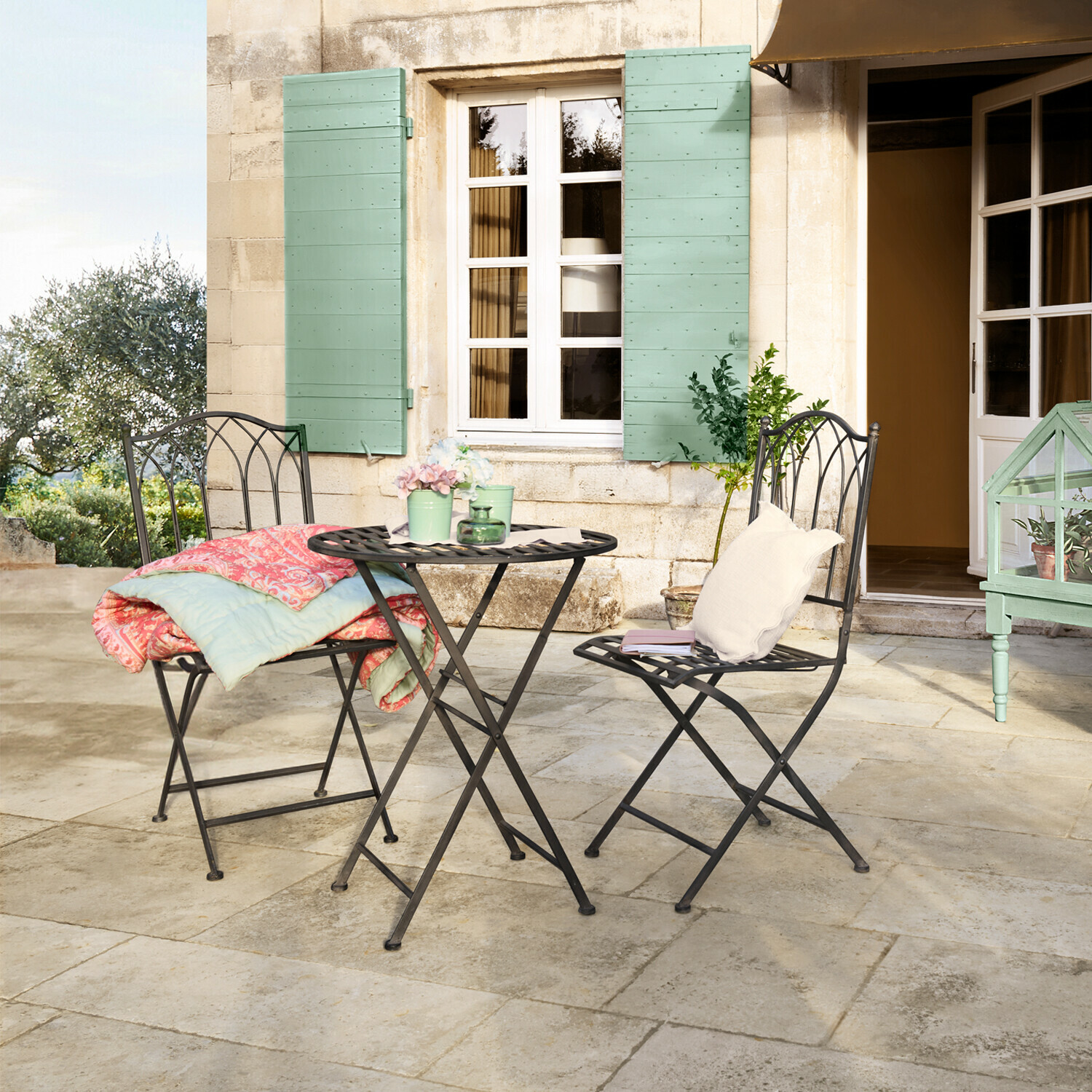 Table et chaises Brignoles Ensemble de mobilier de jardin en métal noir avec deux chaises et une table ronde sur la terrasse