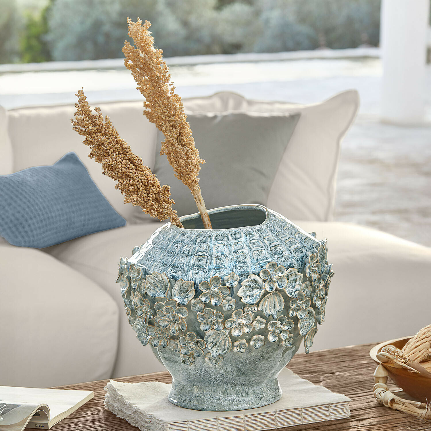 Vase Mireauxine Vase décoratif en céramique bleue avec relief floral posé sur une table en bois dans un salon lumineux