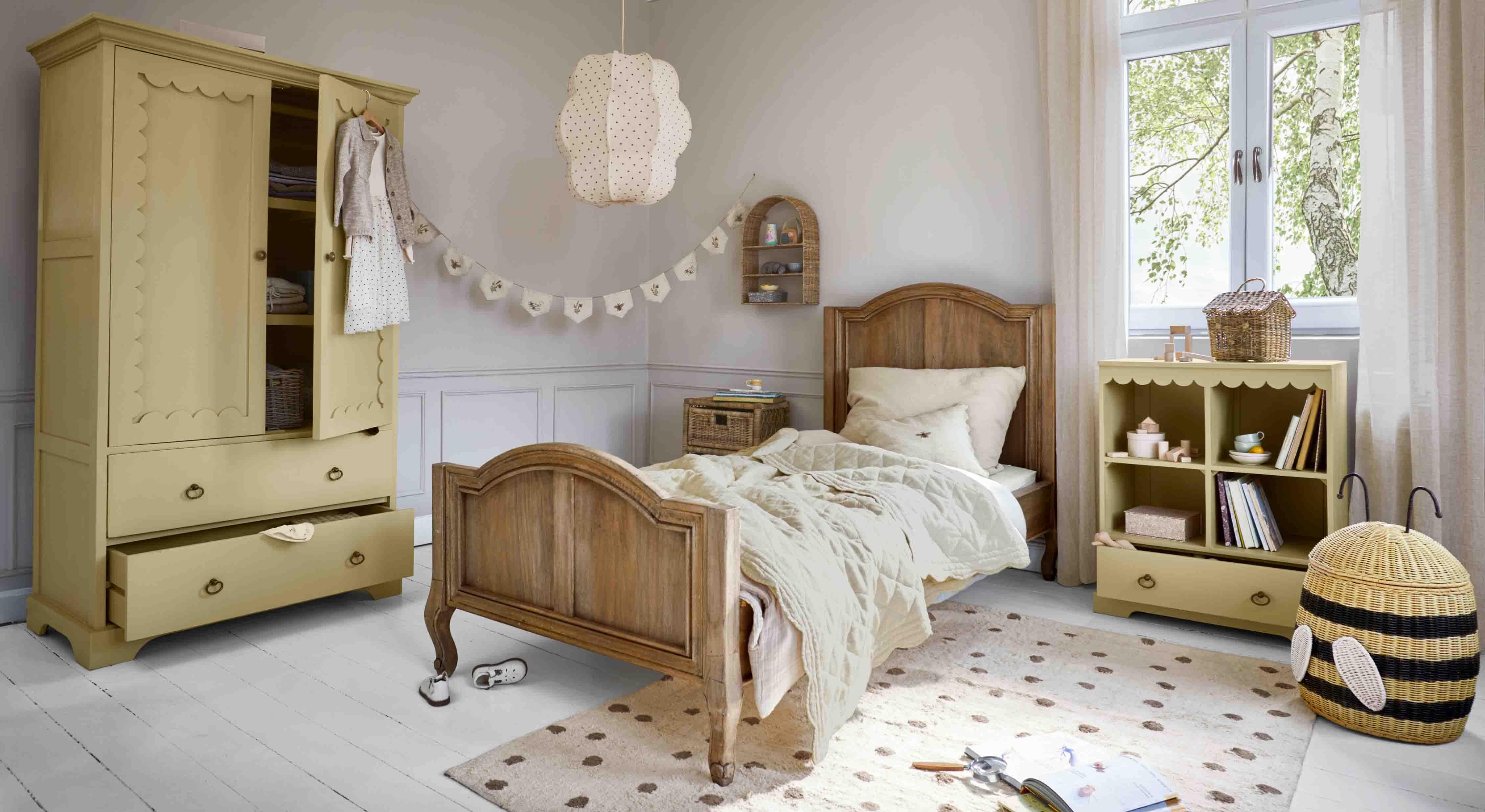 Chambre d'enfant chaleureuse avec lit en bois et armoire jaune, étagère en bois et panier en osier