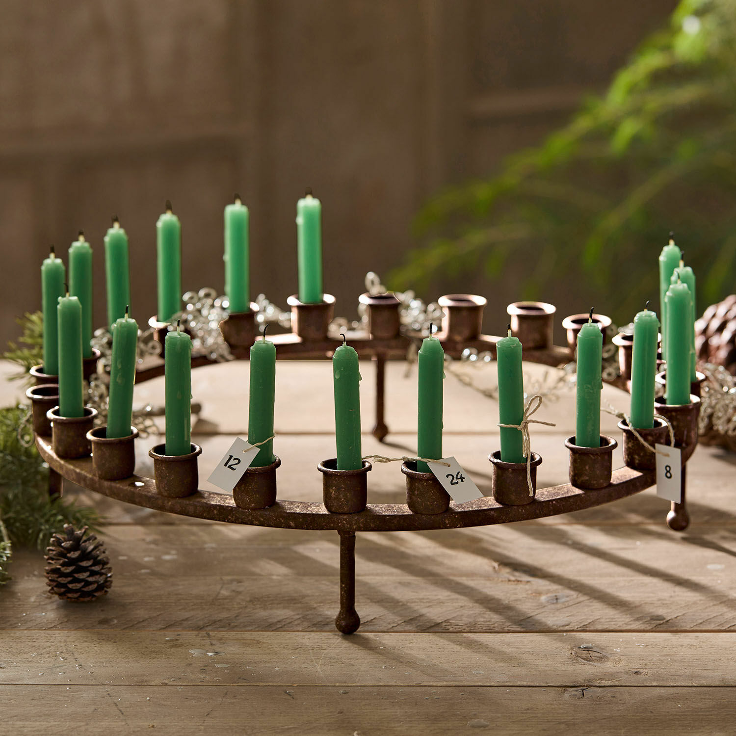 Couronne à bougies Margarit Chandelier en métal rustique avec bougies vertes numérotées sur une table en bois
