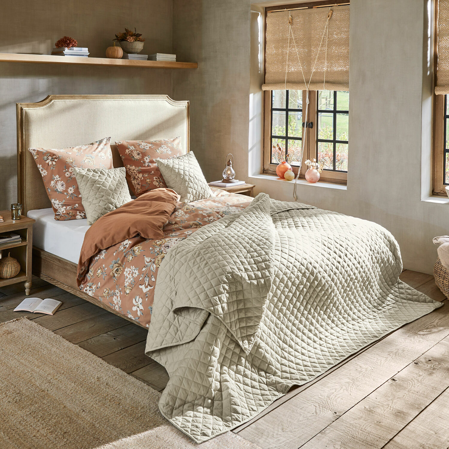 Lit Catham Chambre chaleureuse avec lit en couvre-lit matelassé beige et linge de lit floral aux tons chauds