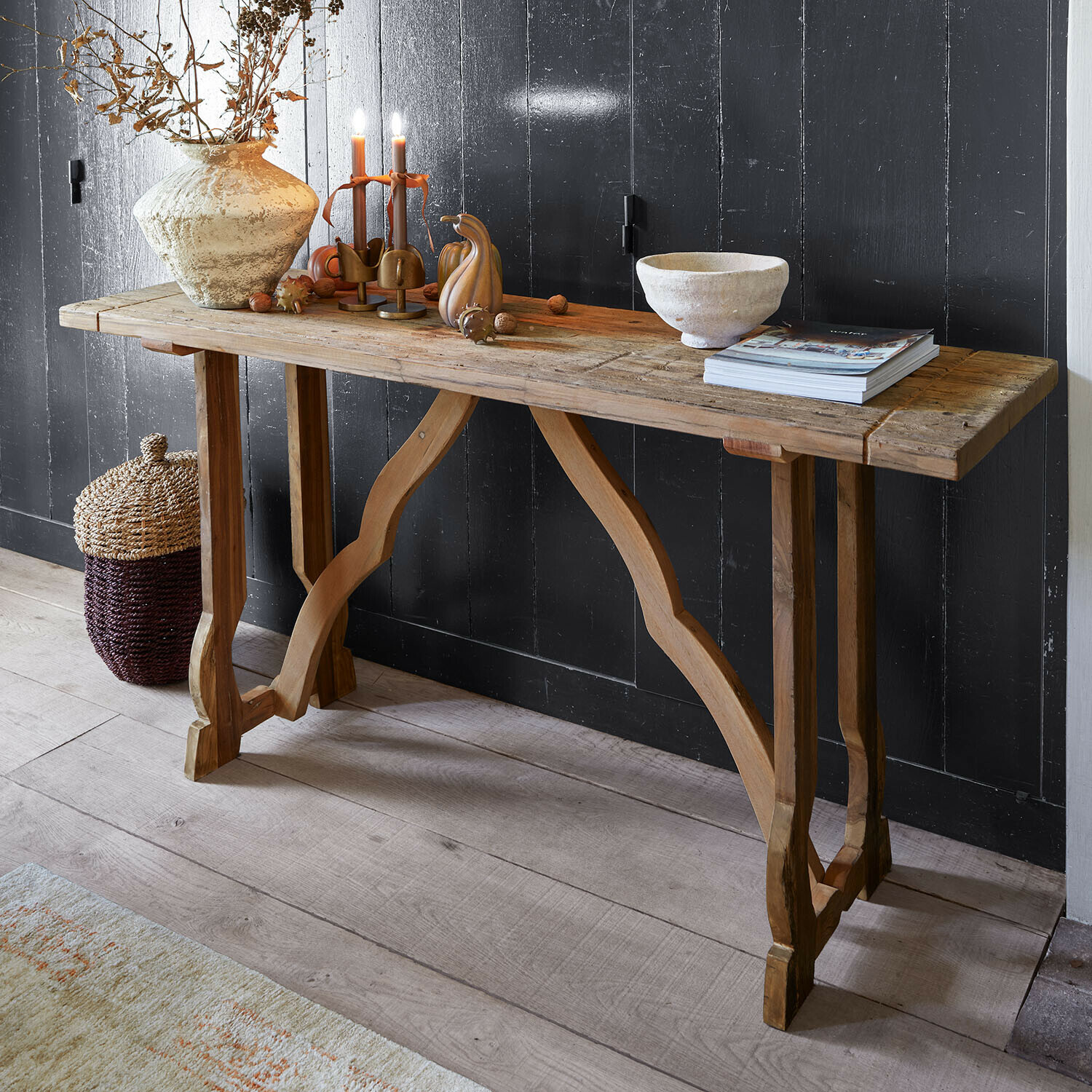 Console Montévine Table console rustique en bois avec décorations et bougies devant un mur noir