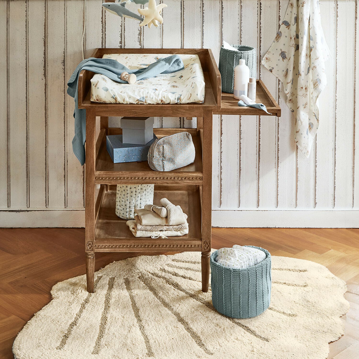 Tapis Vellaro Table à langer en bois avec matelas doux et panier bleu pour couches dans une chambre d'enfant