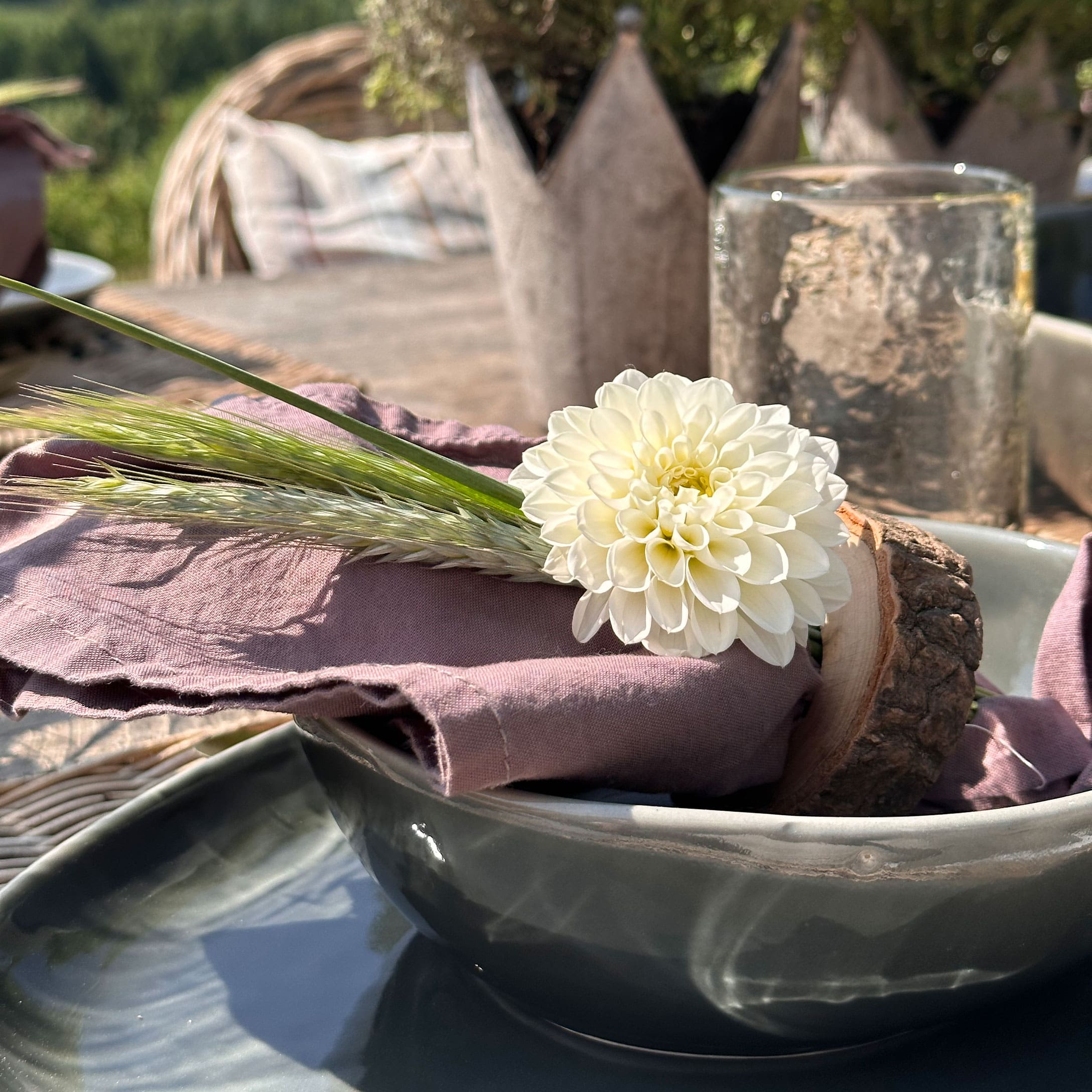 Décoration florale blanche sur serviette en lin rose avec anneau en bois rustique