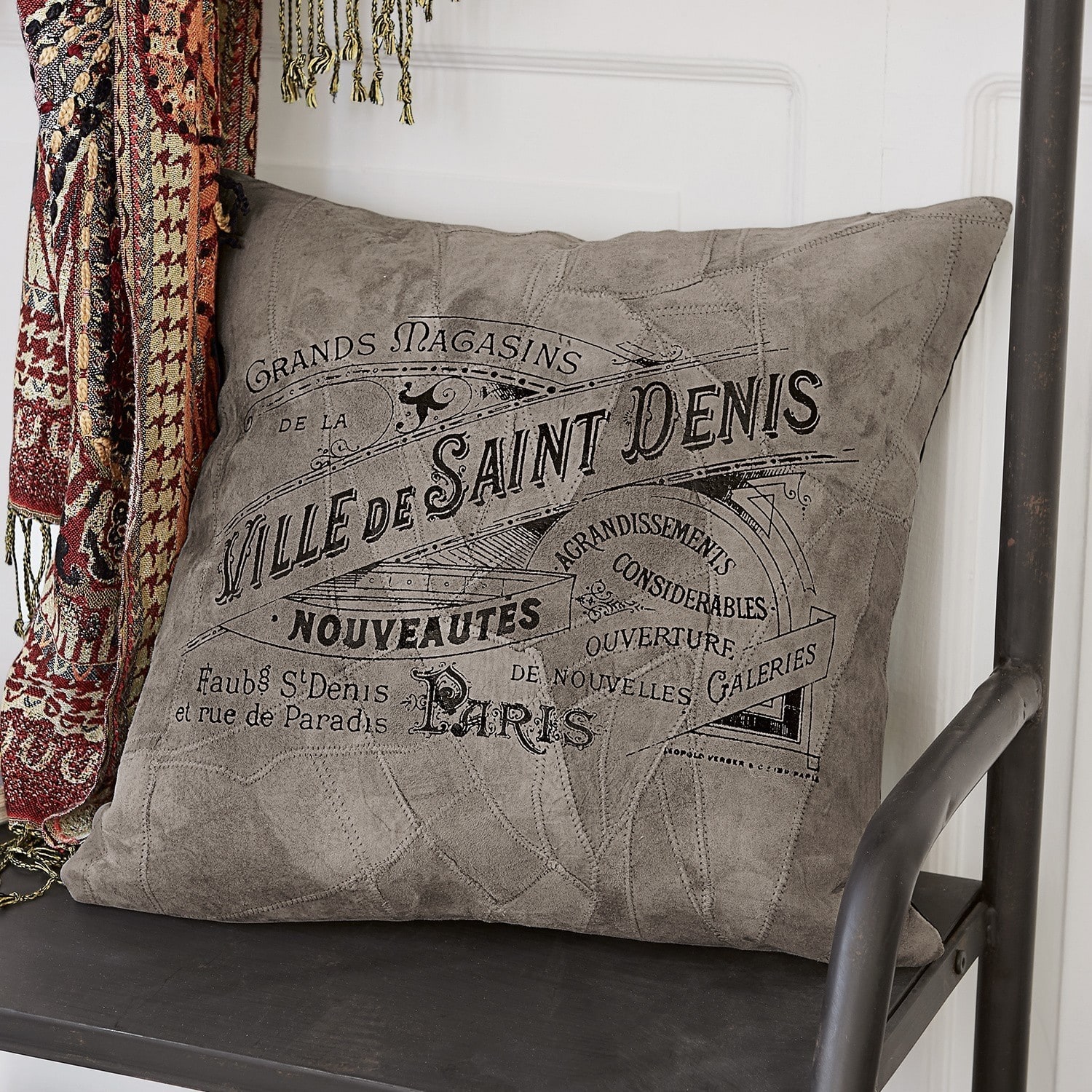 Housse de coussin Boissiére Coussin gris en tissu doux avec impression vintage posé sur une chaise en métal noir