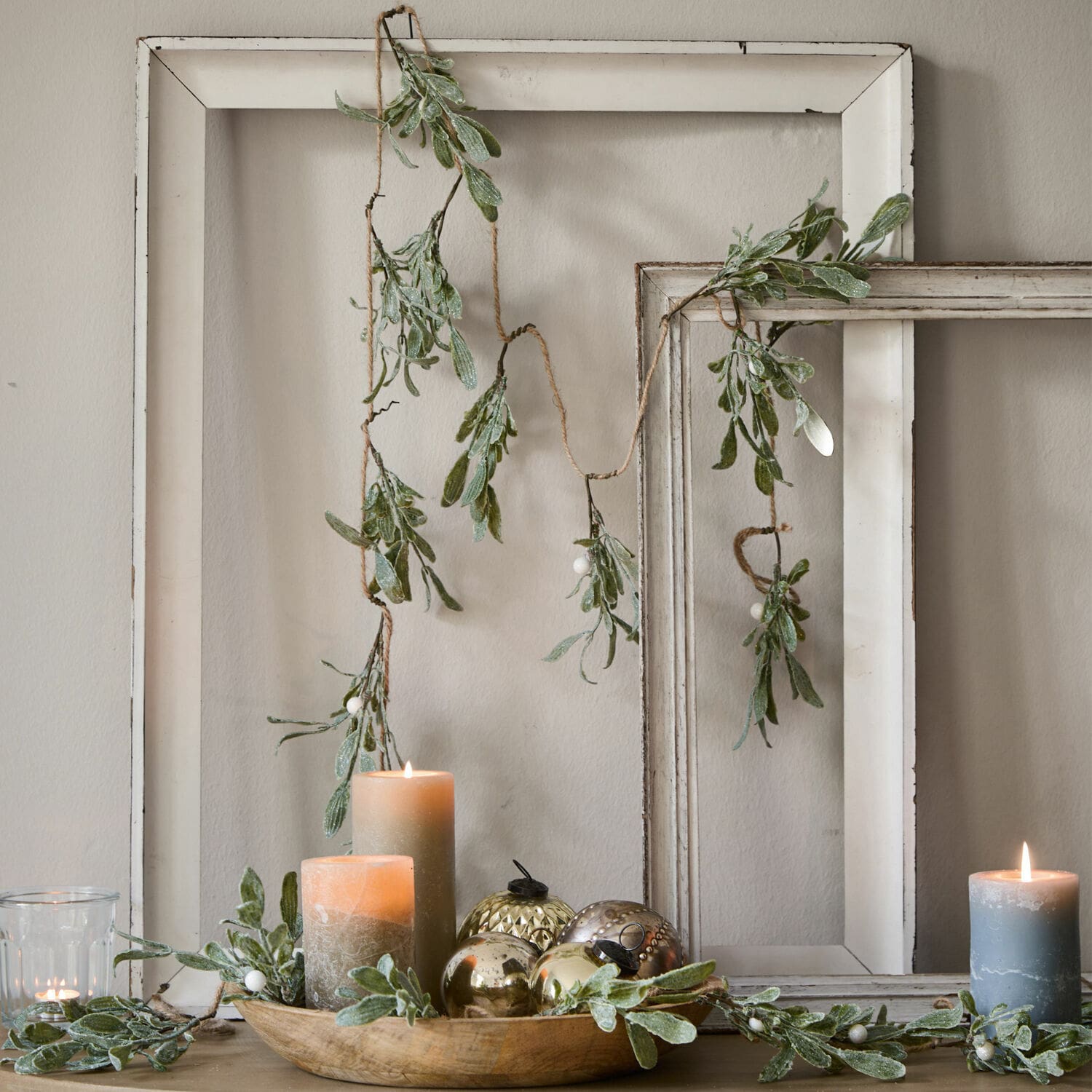 Guirlande Mistletoe Guirlande décorative avec feuilles vertes et baies blanches sur cadres en bois blanc, bougies et décorations