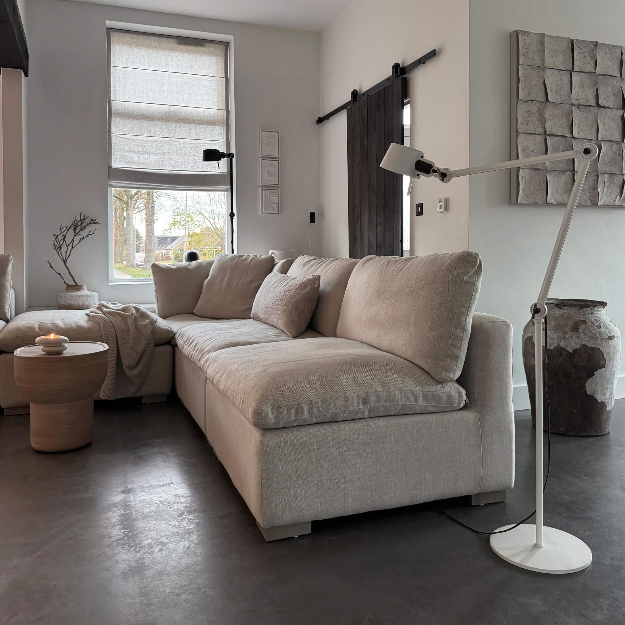 Canapé d'angle beige en tissu dans un salon moderne avec lampe sur pied et table en bois