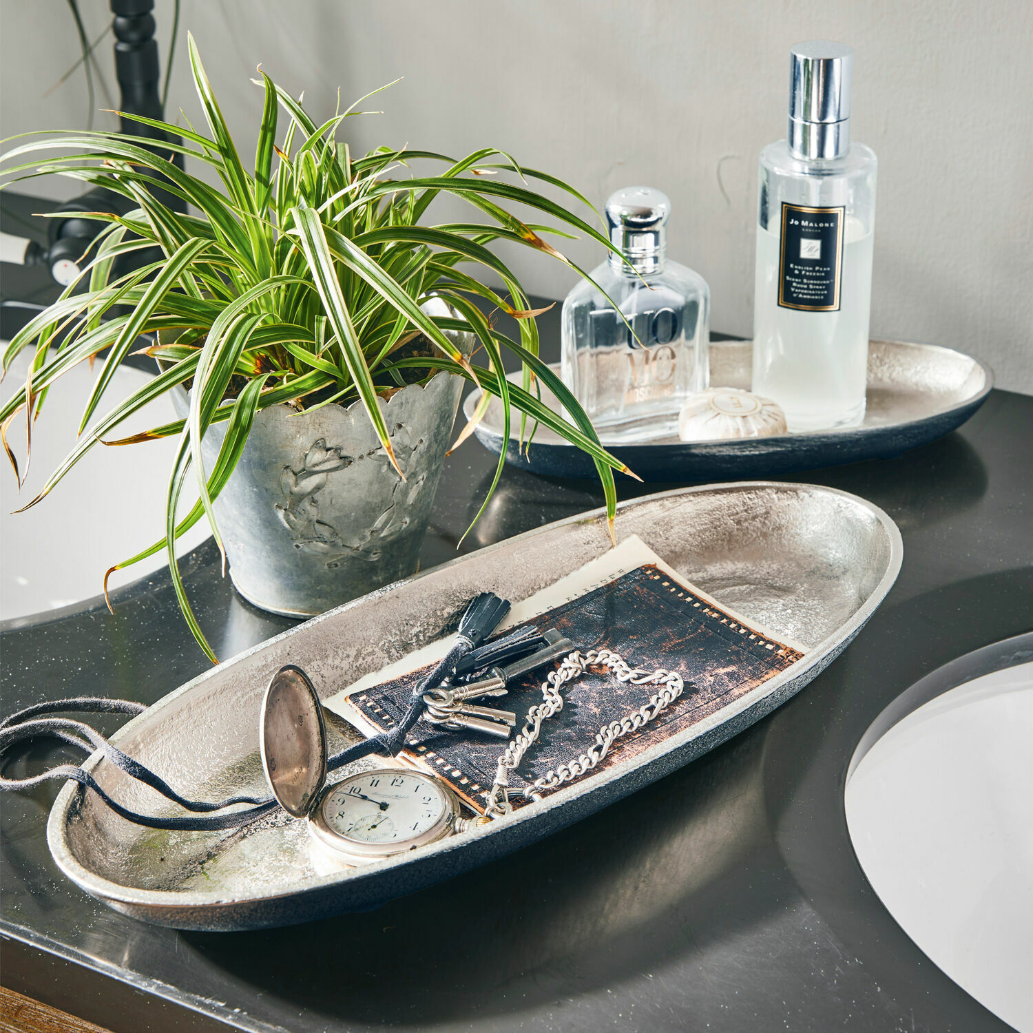 Lot de 2 coupes Marné Plateau décoratif en métal argenté avec clés et montre sur un comptoir de salle de bain noir