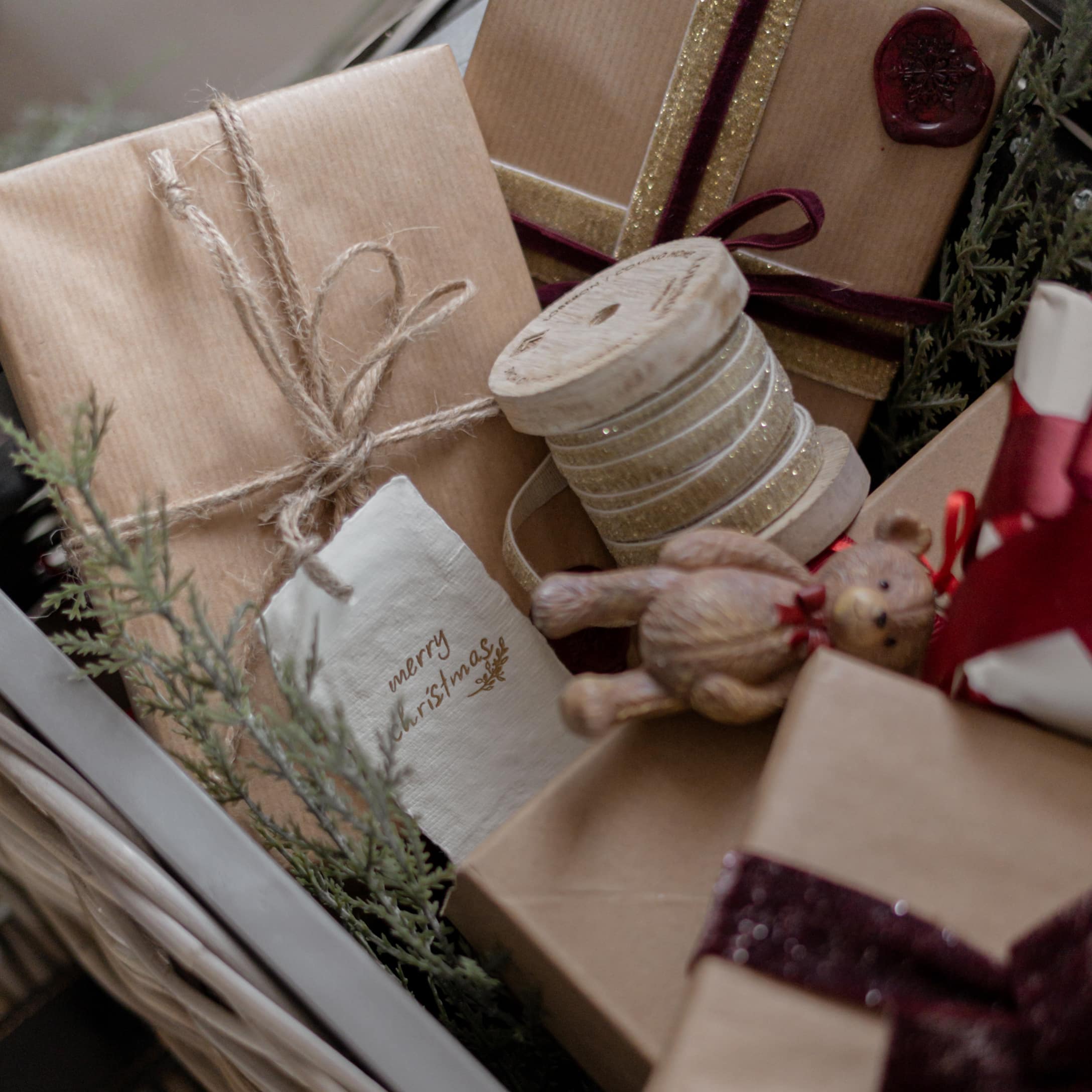 Cadeaux de Noël emballés dans du papier kraft avec rubans décoratifs et ruban en bois scintillant