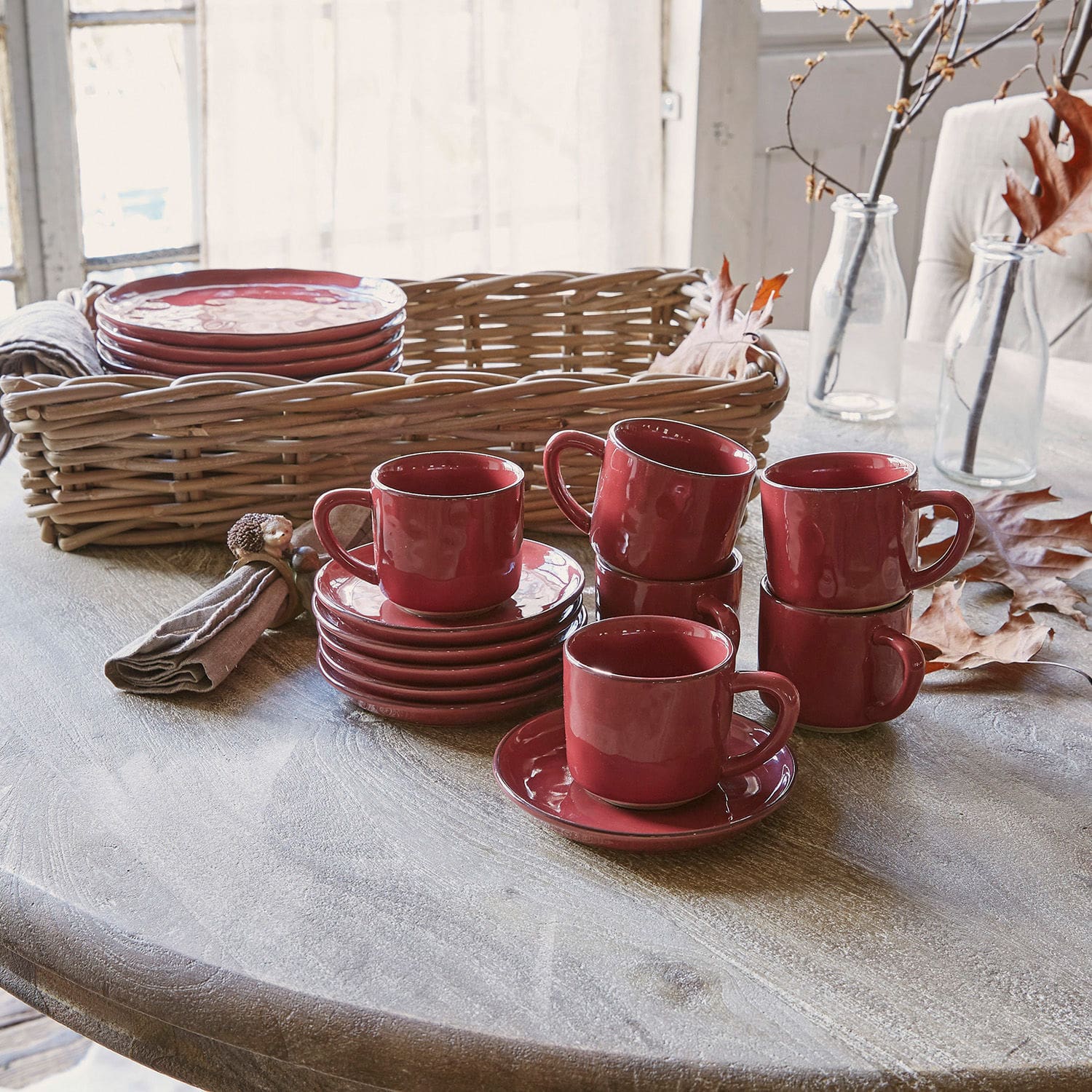 Lot de 6 tasses et soucoupes Biarré Ensemble de tasses et soucoupes en céramique rouge sur table en bois avec panier en osier