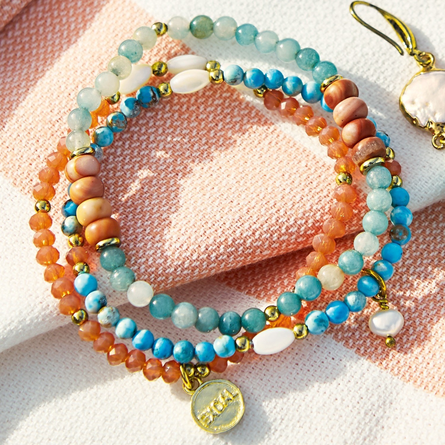 Lot de 3 bracelets Pía Bracelet coloré en pierres naturelles avec éléments dorés sur fond clair, bijou féminin tendance